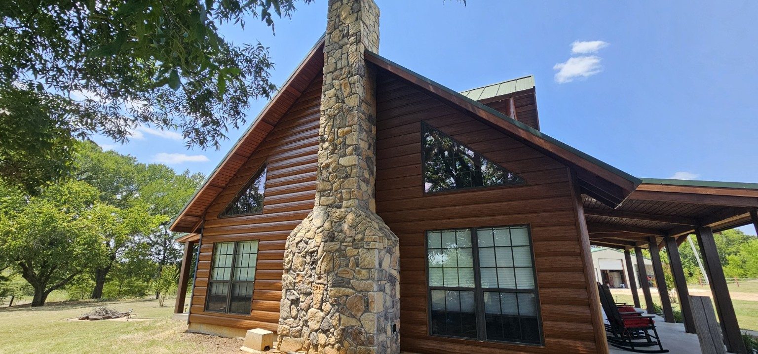 Completed home exterior with stone chimney and covered porch