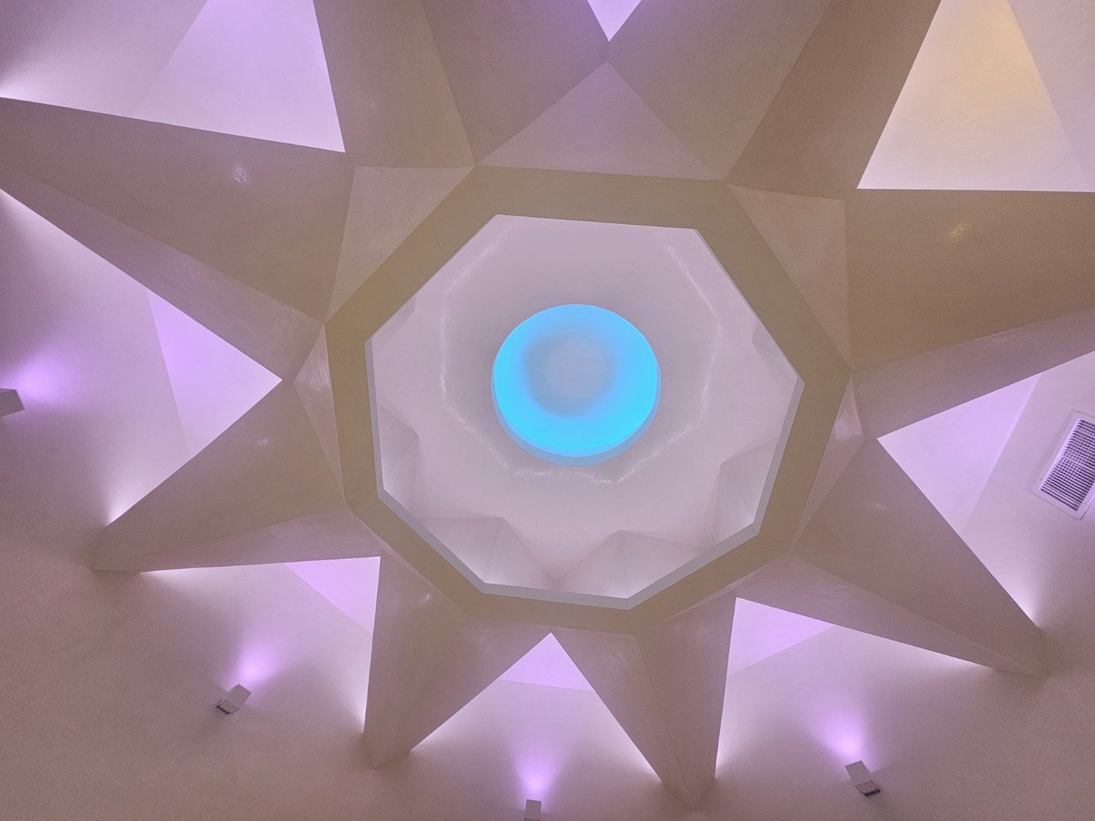 Custom faceted ceiling with recessed lighting and a circular center detail