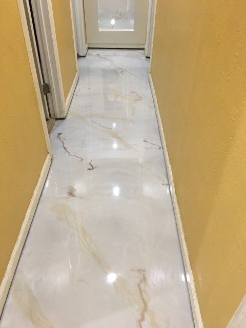 Hallway finished with a white marble-look epoxy floor