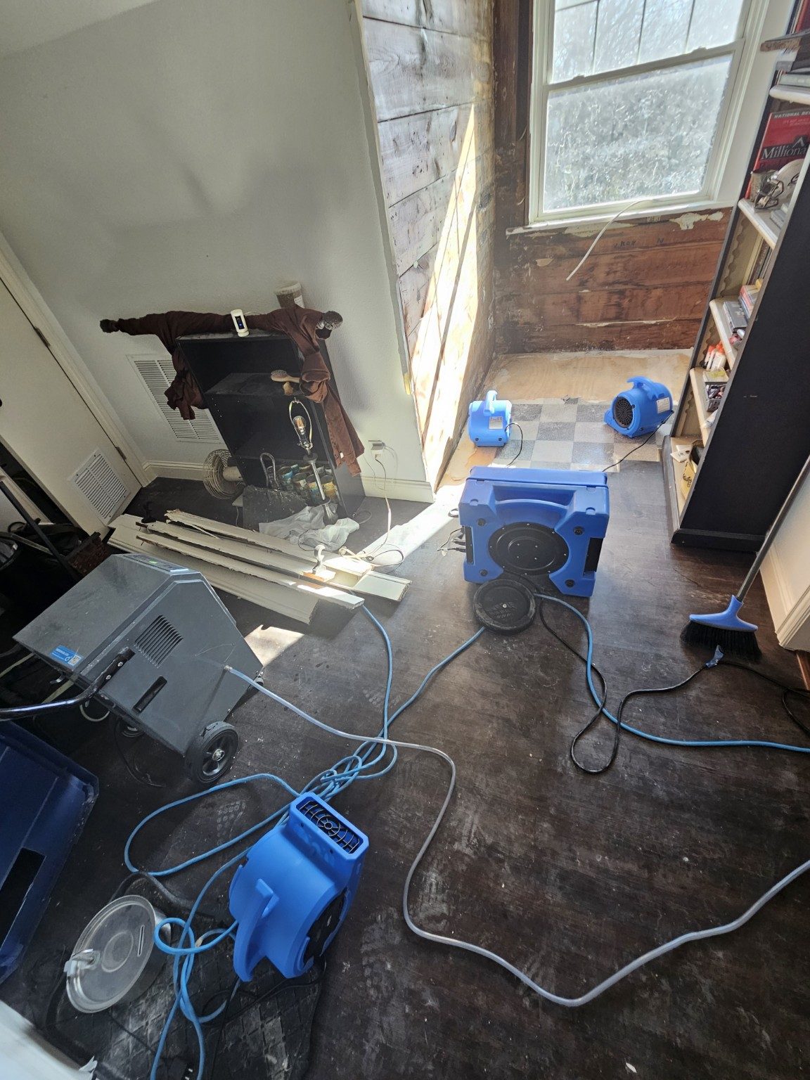 Air movers and dehumidification equipment set up inside a water-damaged home