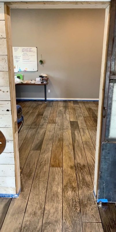 Wood-plank textured stained concrete floor inside a finished interior space